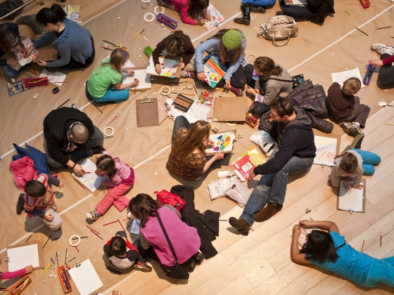 Children and adults sitting on gallery floor coloring Children and adults sitting on gallery floor coloring