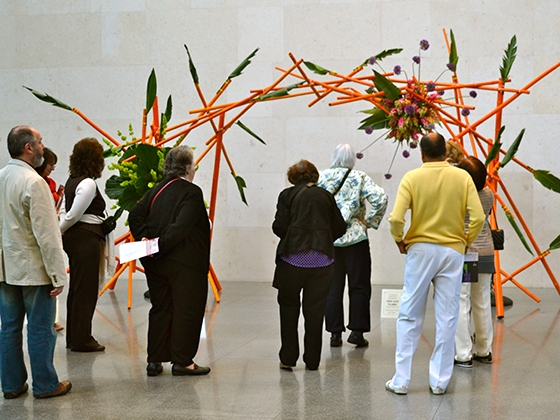 Visitors looking at arched flower arrangement in the Shapiro Courtyard Visitors looking at arched flower arrangement in the Shapiro Courtyard