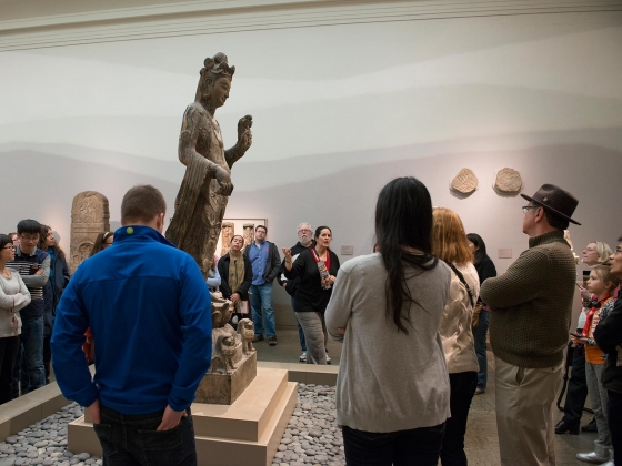 Visitors standing around statue of Guanyin, listening to guide Visitors standing around statue of Guanyin, listening to guide