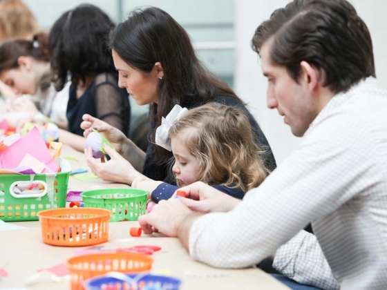 Parent helping child apply glue onto paper craft project