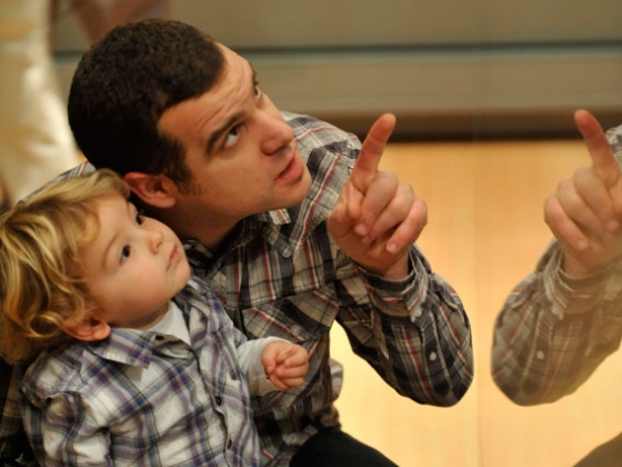 Father with child pointing up at display case Father with child pointing up at display case