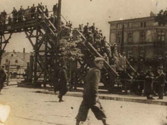 Henryk Ross, Lodz Ghetto: Boy walking in front of the bridge crossing Zigerska (the "Aryan") street, 1940-44 Henryk Ross, Lodz Ghetto: Boy walking in front of the bridge crossing Zigerska (the "Aryan") street, 1940-44